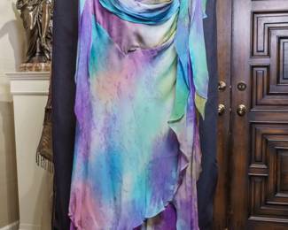 LOT 51 – Pastel Multi-colored Silk Chiffon Dress and Evening Wear Ensemble. A sophisticated pastel, multi-colored silk chiffon evening dress featuring a graceful draped ruched neckline and a flowing, layered, asymmetrical tiered skirt. Lightweight, cool, and breezy, the dress comes with two matching chiffon scarves/wraps in lavender and aqua, plus a vintage-looking handmade lavender beaded handbag for a complete, elegant ensemble. All elements of this outfit were designed and crafted by famous fashion and costume designer Margi Kent. Photographed with all coordinating elements, as well as the front, back, label and lining details. This full fashion outfit is sold as a full ensemble set. • Approx. Size ~8 to 8/10; Approx. Measurements: Waist: 30”, Bust: 36, Hips: 36. • Sizing note from the owner: the gowns can be adjusted easily, larger or smaller, as there is plenty of fabric in the seams.