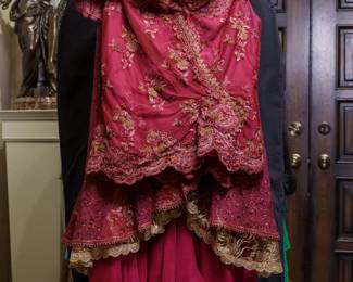 LOT 66 – Dramatic Hot Red & Gold Embroidered Evening Ensemble. A breathtaking hot-red net evening gown richly embellished with gold embroidery, featuring exquisite gold lace and floral appliqués, an elegant red ruched camisole with a softly ruched collar, and beautiful scalloped gold-trimmed hem. The gown is accompanied by a stunning matching caplet, designed to drape gracefully around the shoulders, providing an elegant finishing touch—and an extra layer of warmth should the evening turn cooler. The skirt is truly extraordinary, constructed in three dramatic, layered tiers. Designed by famous fashion and costume designer Margi Kent. Sold as a full ensemble set. • Approx. Size ~8 to 8/10; Approx. Measurements: Waist: 30”, Bust: 36, Hips: 36. • Owner’s note: the gowns can be adjusted in size; there is plenty of fabric in the seams.