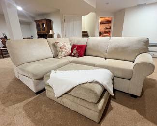 Neutral upholstered sectional sofa with chaise and matching storage ottoman