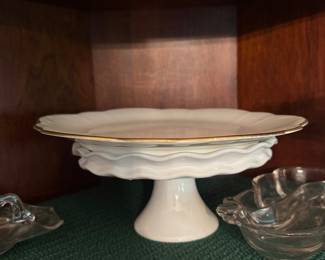 White ceramic pedestal cake stand with gold rim and pressed glass dishes