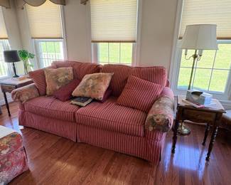 Red striped upholstered loveseat with throw pillows