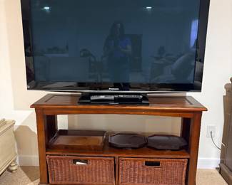 Flat screen TV on wood media console with wicker basket drawers