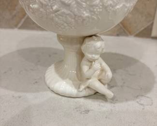 White porcelain pedestal bowl with seated cherub base