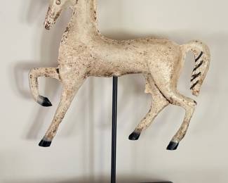 Distressed carousel horse sculpture on metal stand