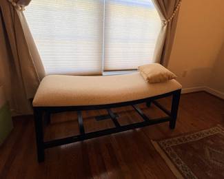 Upholstered bench with dark wood frame and lower rack