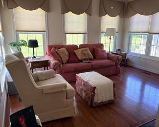 Sunroom with wingback chair, red striped loveseat, ottoman, and lamps