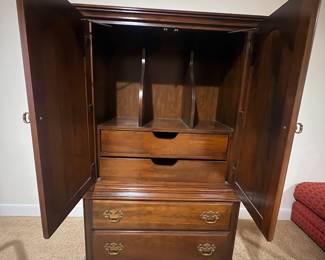 Armoire interior with adjustable dividers, pull out drawers, and storage drawers below