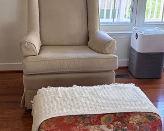 Cream upholstered wingback chair with floral ottoman