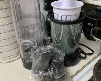 Magic Bullet style personal blender with a green marbled base, multiple clear blending cups, and accessories.