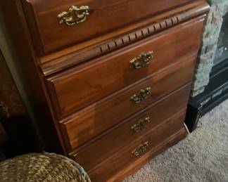 Traditional five-drawer wooden chest of drawers featuring ornate brass pull handles and a warm cherry finish.