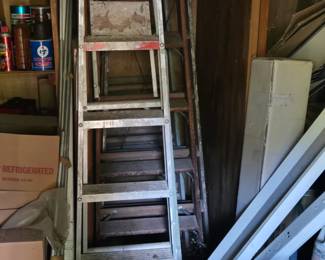 Lots of wooden and aluminum ladders