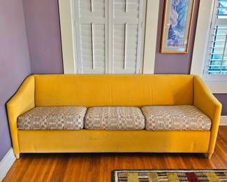 MCM style sofa, mustard yellow, with swooping, angled arms.