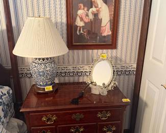 Side table, lamp, vanity mirror and perfume bottles, framed print