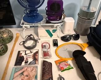 Table with portable fans, sunglasses and small electronics