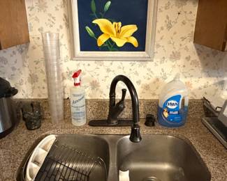 Kitchen sink with framed lily print above