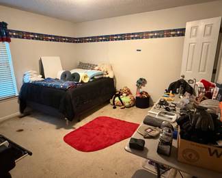 Child's bedroom with twin bed, toys and red accent rug