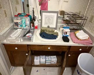 Bathroom vanity with linens, toiletries and wire shelving