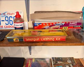 Shelf with shotgun cleaning kit, license plate and boxed games