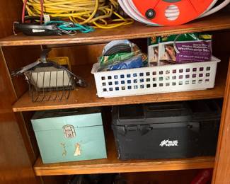 Wood shelf with extension cords, hose reel and storage baskets