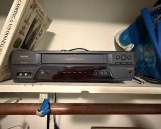 Toshiba VCR and camping reference books on shelf