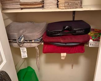 Linen closet stocked with towels, sheets and serving trays