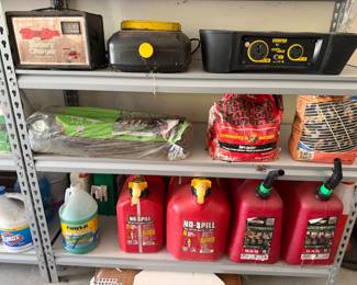 Gas cans, battery charger and bagged mulch on shelving