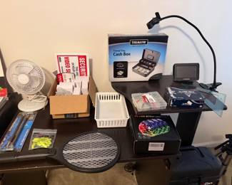 Desk with cash box, portable fans, task lamp and office supplies