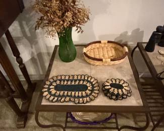 Metal and glass console table with dried floral arrangement and beaded mats