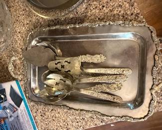 Silverplate serving tray with ornate serving spoons and ladles