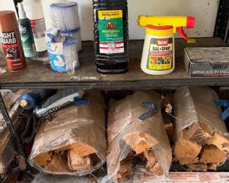 Garage shelf with bagged firewood and maintenance supplies