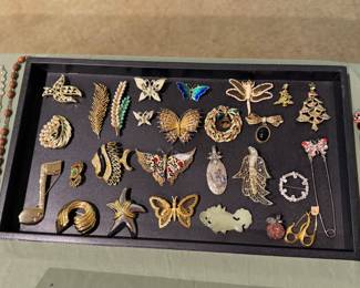 Display tray of vintage brooches including butterflies, dragonfly and enamel pins