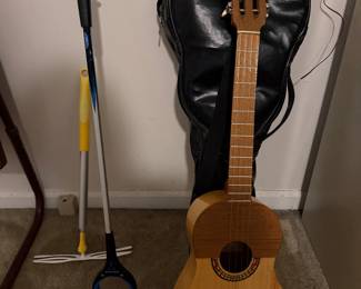 Acoustic guitar with soft case and garden tools