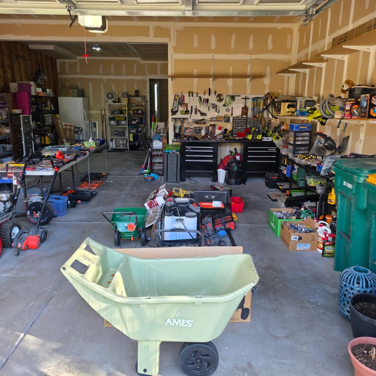 garage full of tools, lawn care equipment, and workshop items.