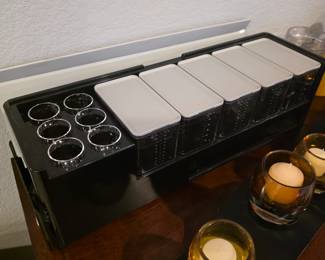 Black plastic bar caddy garnish condiment dispenser with six spice containers and glass cutouts