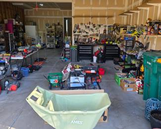 garage full of tools, lawn care equipment, and workshop items.