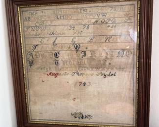 This is a framed piece of vintage embroidery, showing calligraphy.