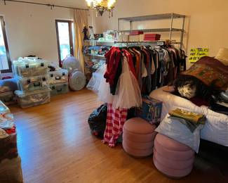 There are some clothes in the sale, as can be seen on the rack.  There are shelves with more items in the background, and several plastic boxes with more treasures.