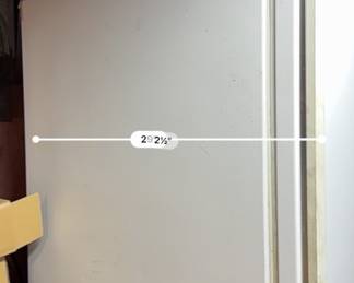 White upright freezer measuring 29.5 inches wide, showing minor exterior scuffs and light wear.