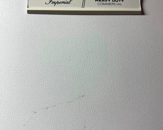 Close-up detail of an Imperial Heavy Duty Commercial appliance badge on a textured white exterior.