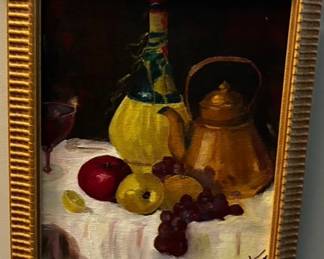 Traditional still-life painting depicting fruit, grapes, bottles, and a copper-toned kettle, presented in a decorative gold-tone frame