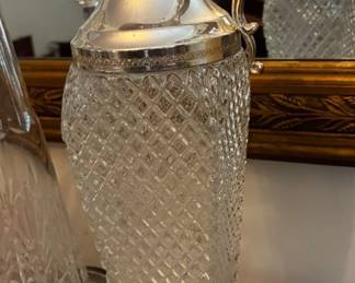 Elegant patterned glass ewer featuring ornate silver-tone metalwork, a decorative spout, and a gracefully curved handle.
