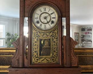 Traditional wooden grandfather clock with decorative brass-tone dial and pendulum case.