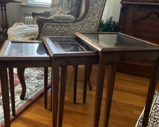 Charming set of three coordinating wood nesting tables with glass tops. Use them together or separate them throughout a room for extra side-table space when needed.