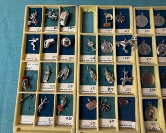 R.L. Griffith & Son Charms marked sterling. Some are slightly attracted to magnet, most not. Tested with 18k acid and showed sterling. Just full transparency to make choice. 