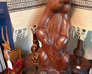 Large wood carving of beaver with Native American wool weaving behing.