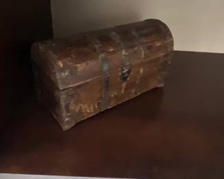 Small rustic wooden dome-top treasure chest with metal straps and a distressed finish.