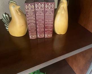 Pair of carved wooden chicken bookends with brass accents flanking three vintage Reader's Digest Condensed Books from the 1950s.