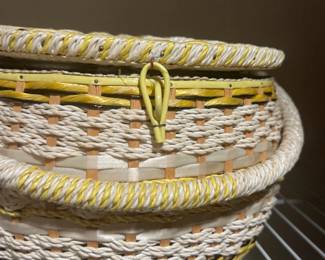 Vintage round woven sewing basket in yellow and cream tones, featuring a loop closure and thick wrapped handle.