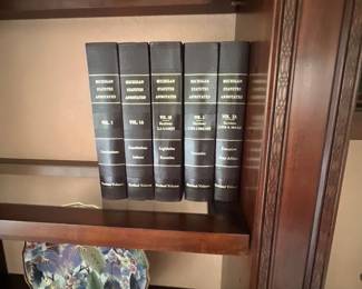 Five-volume set of hardbound "Michigan Statutes Annotated" legal reference books, displayed on a wooden shelf.