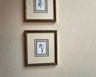 Pair of framed botanical prints featuring blue iris illustrations with striped inner matting and ornate gold-tone frames.